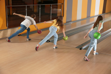 Photo of Group of friends throwing balls in bowling club