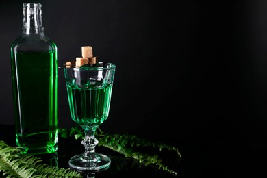 Photo of Absinthe, brown sugar and green leaves on mirror table, space for text. Alcoholic drink