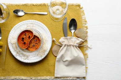 Photo of Autumn table setting with dried pumpkin slices on white wooden background, flat lay