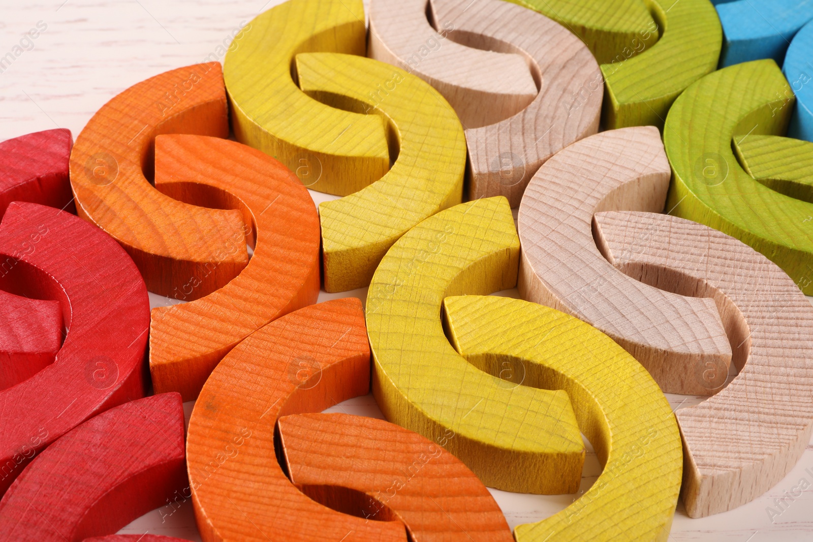 Photo of Colorful wooden pieces of playing set on white table, closeup. Educational toy for motor skills development