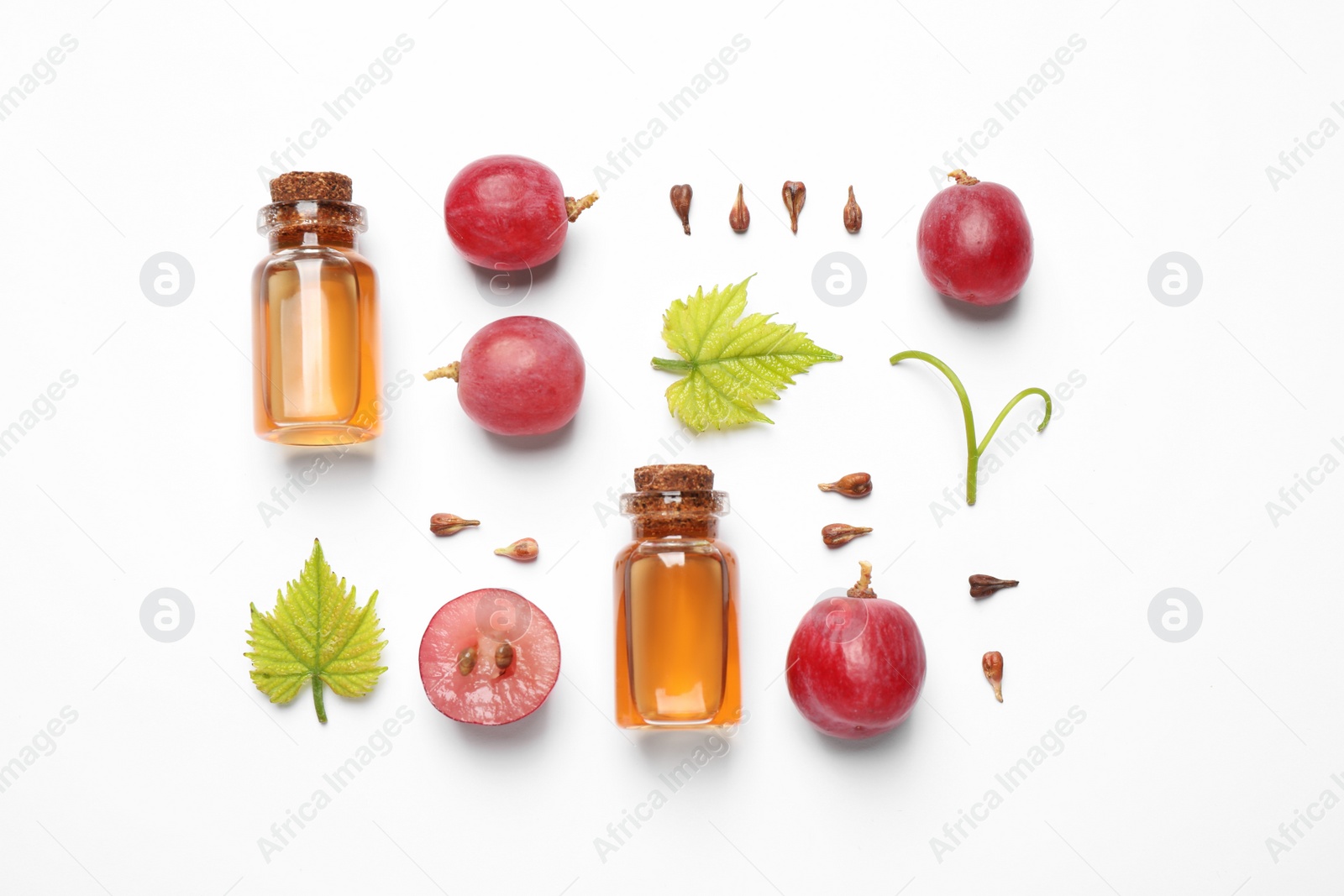 Photo of Flat lay composition with natural grape seed essential oil on white background. Organic cosmetics