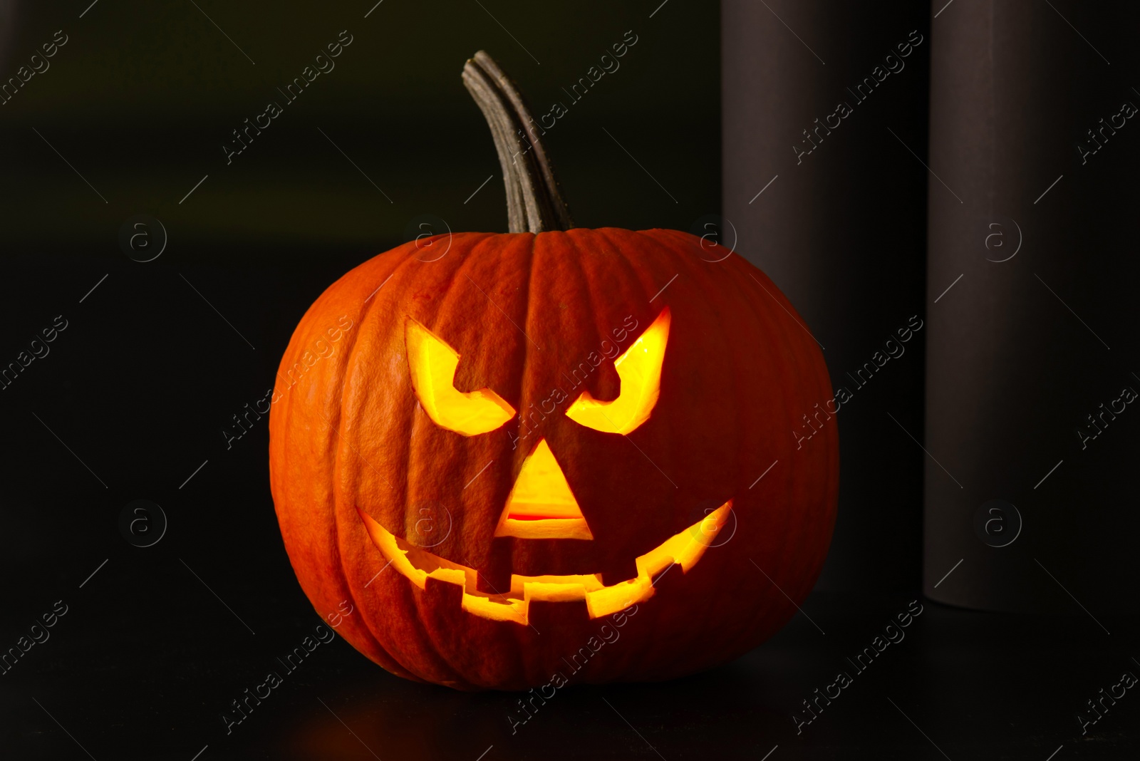 Photo of Scary jack o'lantern pumpkin in darkness. Halloween decor