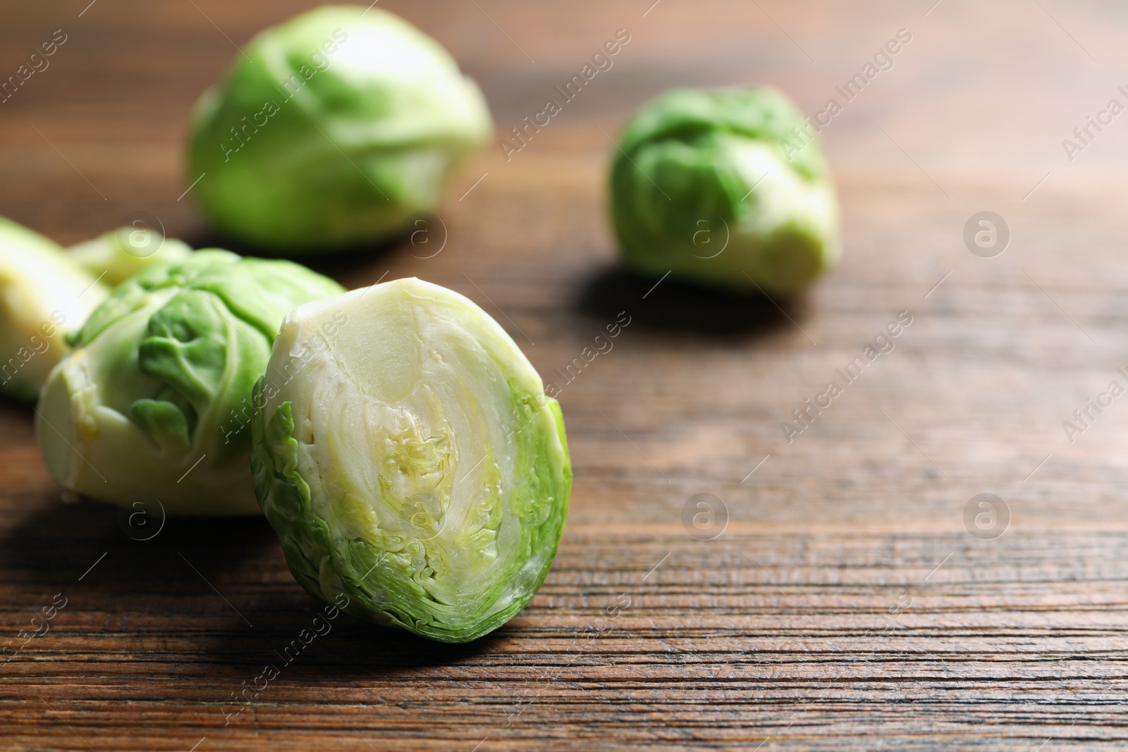 Photo of Fresh Brussels sprouts on table, closeup. Space for text