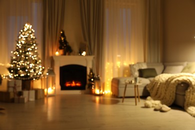 Stylish living room interior with Christmas tree near beautiful fireplace, blurred view