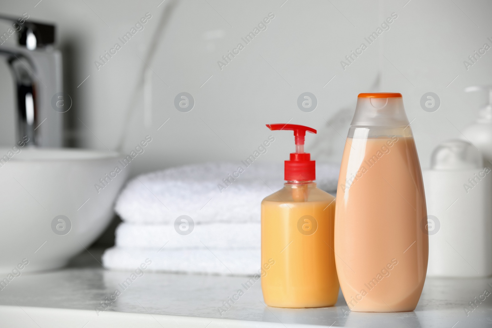 Photo of Shampoo and liquid soap near sink on bathroom counter, space for text