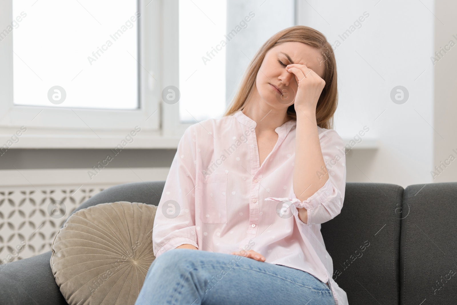 Photo of Overwhelmed young woman suffering from headache at home