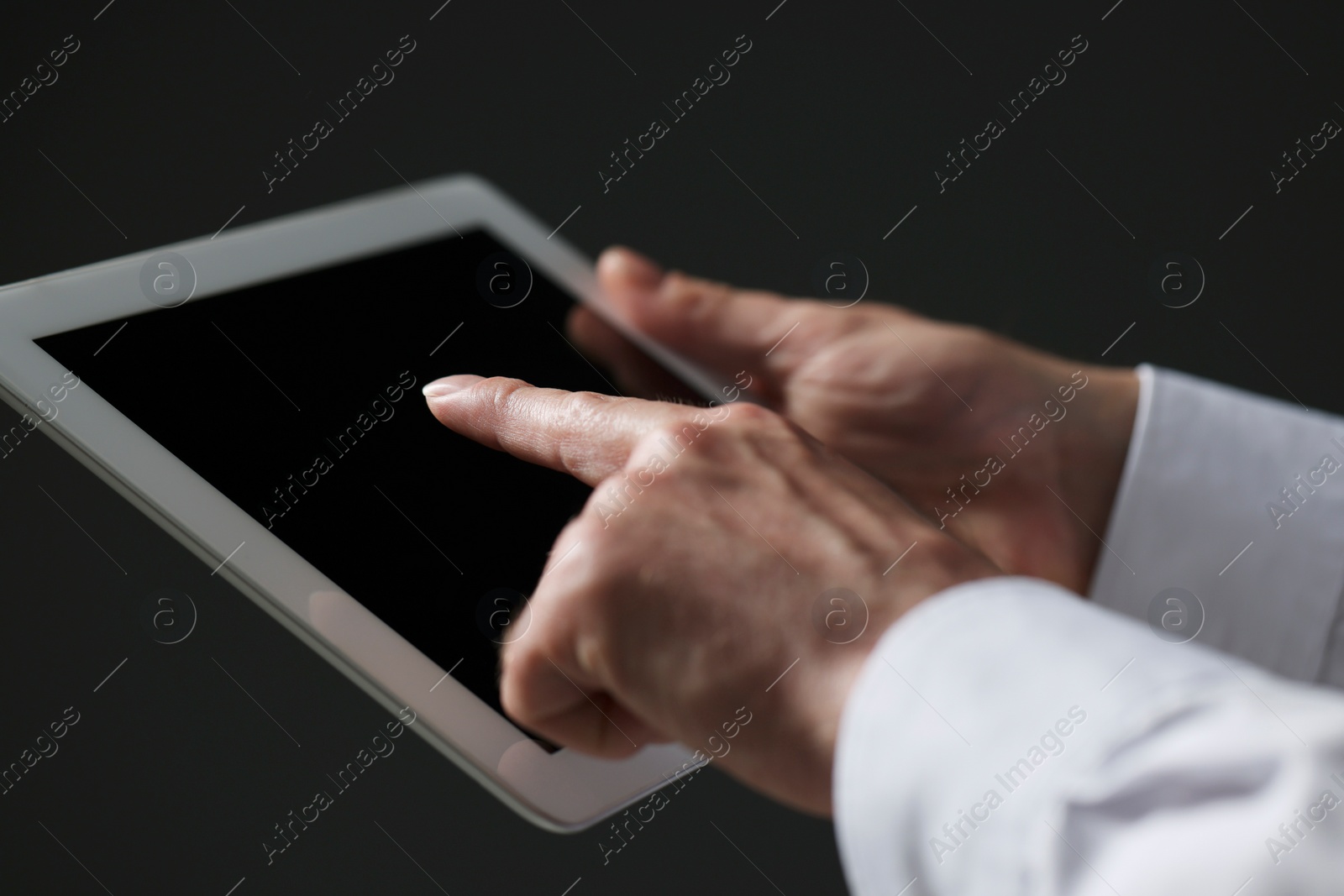 Photo of Closeup view of man using new tablet on black background