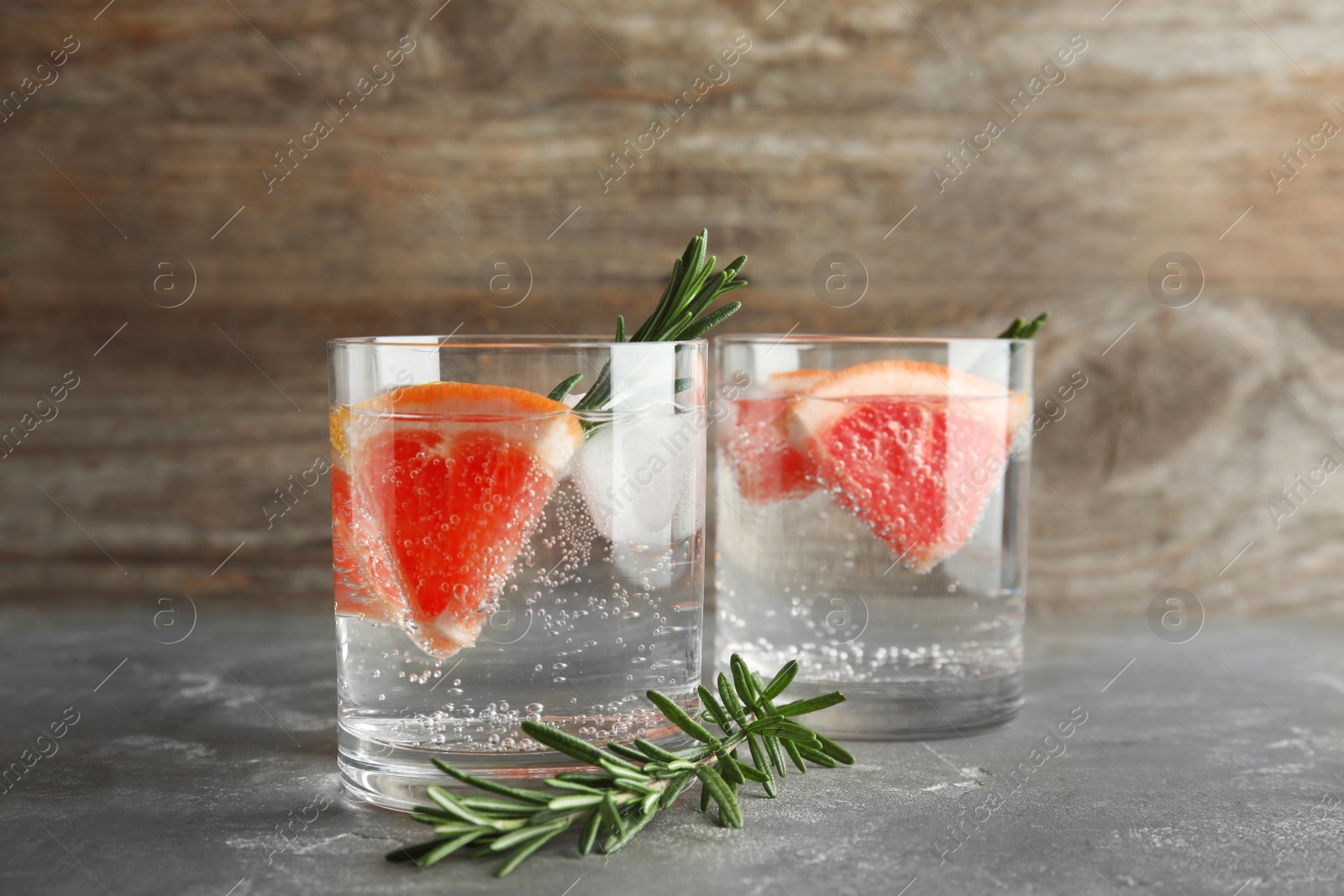 Photo of Glasses of infused water with grapefruit slices on table