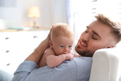 Photo of Father with his newborn son at home