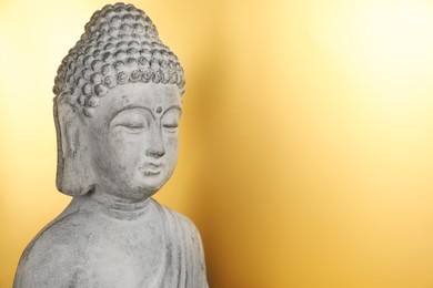 Buddha statue on golden background, closeup. Space for text