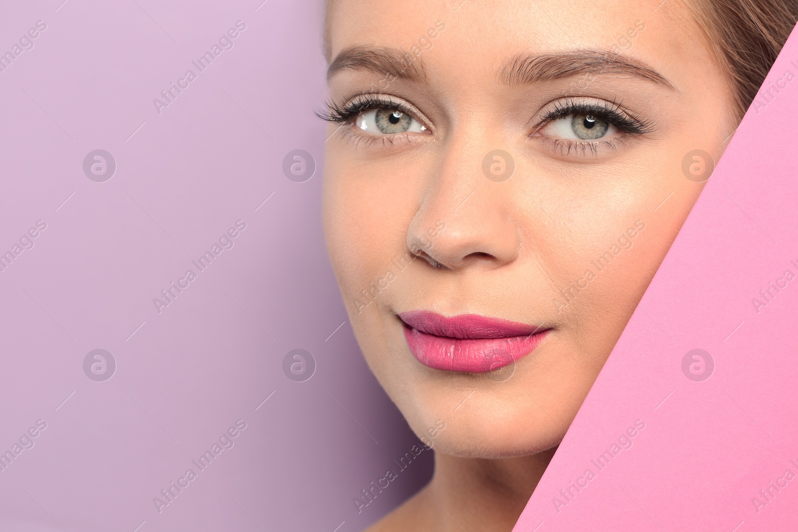 Photo of Young woman wearing beautiful lipstick on color background. Space for text