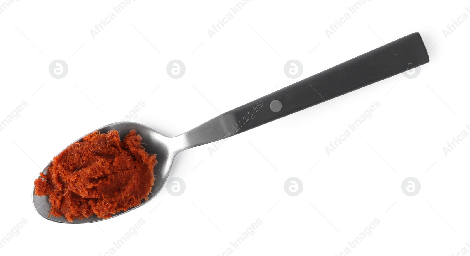 Photo of Tasty curry paste in spoon isolated on white, top view