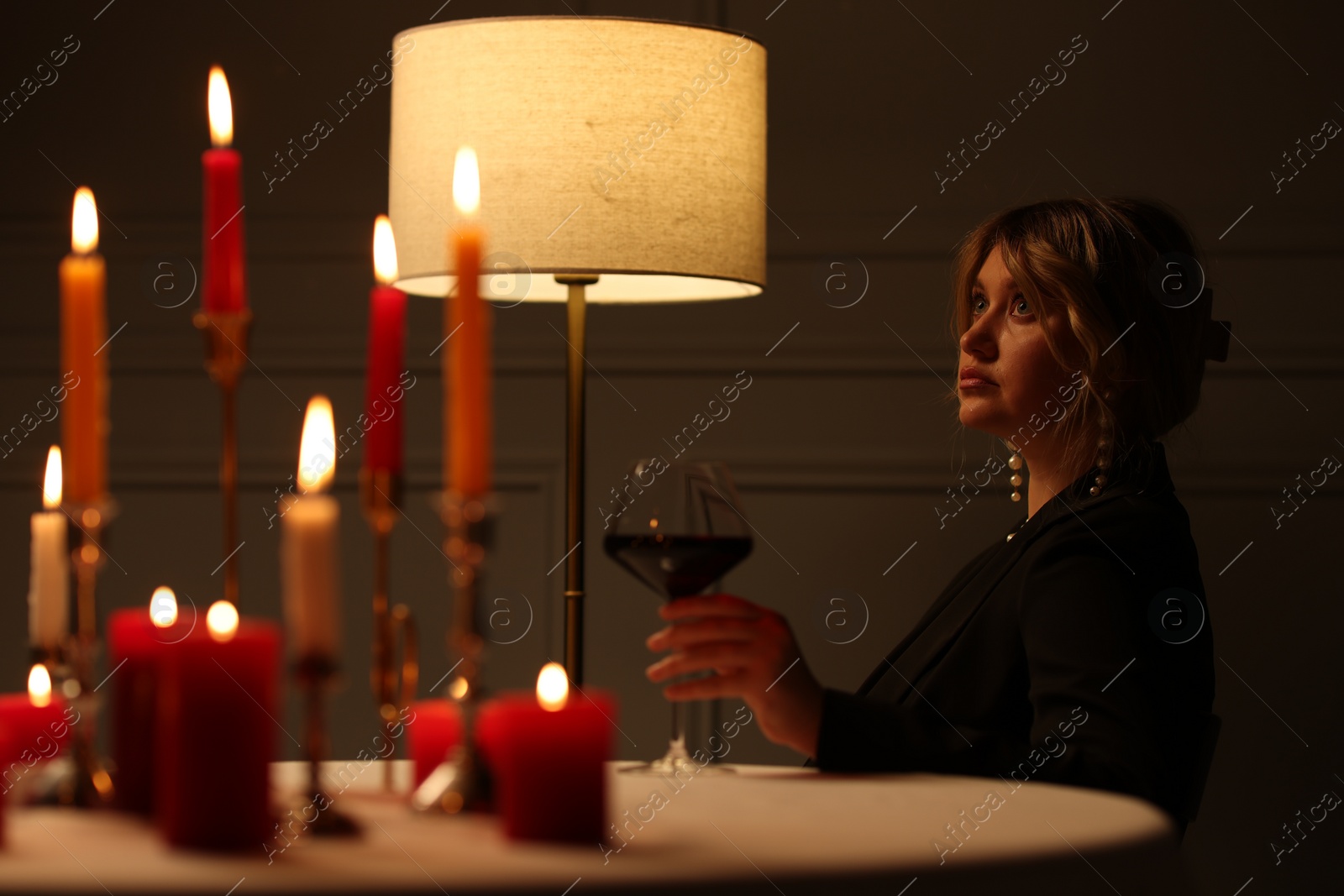 Photo of Beautiful young woman with glass of wine at table in restaurant