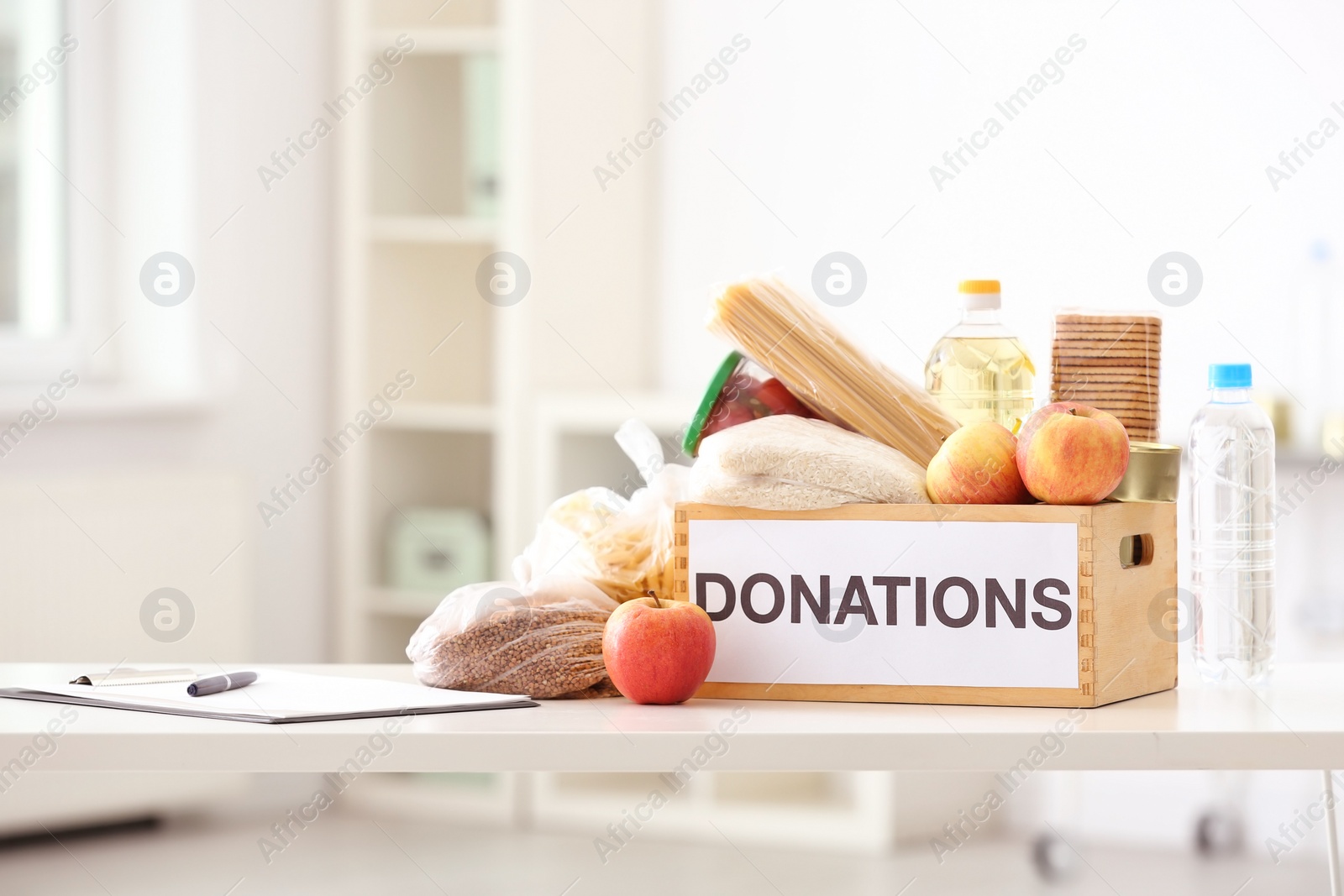 Photo of Donation box with food products on table indoors