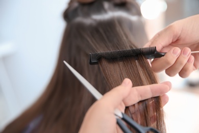 Photo of Professional hairdresser working with client in salon