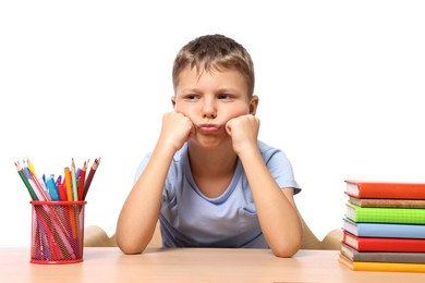 Little boy with stationery and stack of books suffering from dyslexia at wooden table
