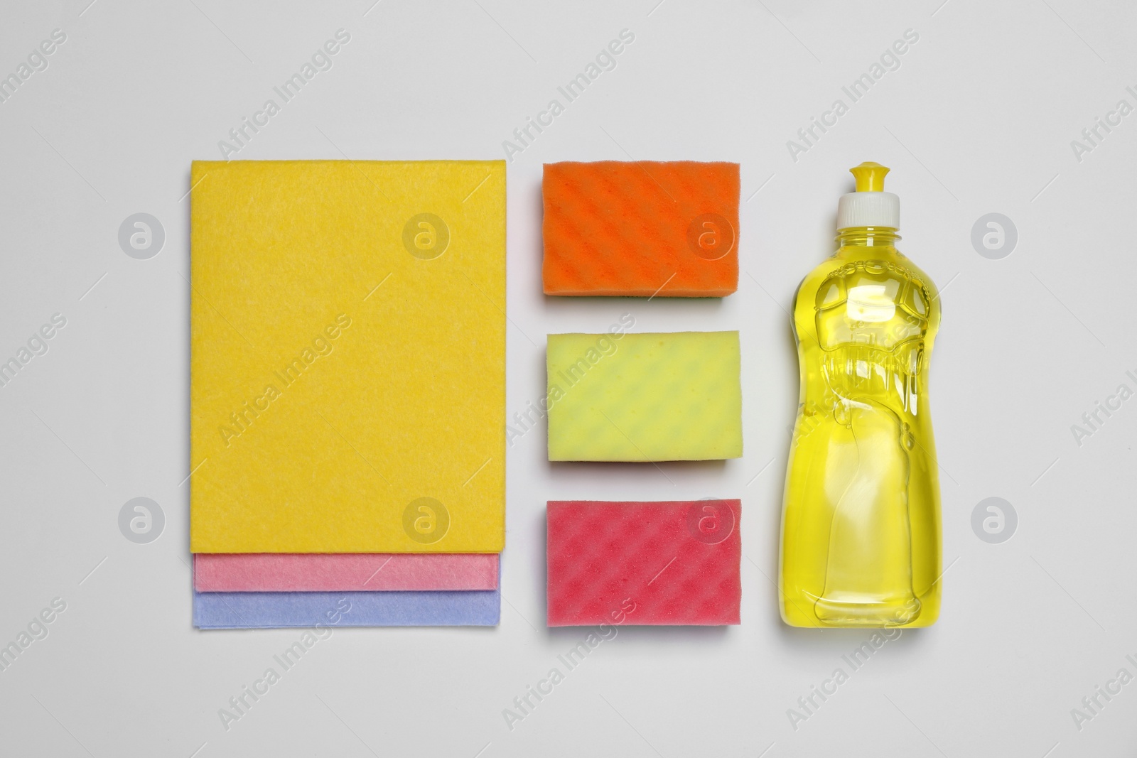 Photo of Sponges and other cleaning products on white background, flat lay