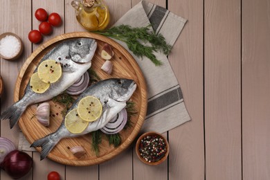 Photo of Flat lay composition with raw dorado fish on wooden table. Space for text