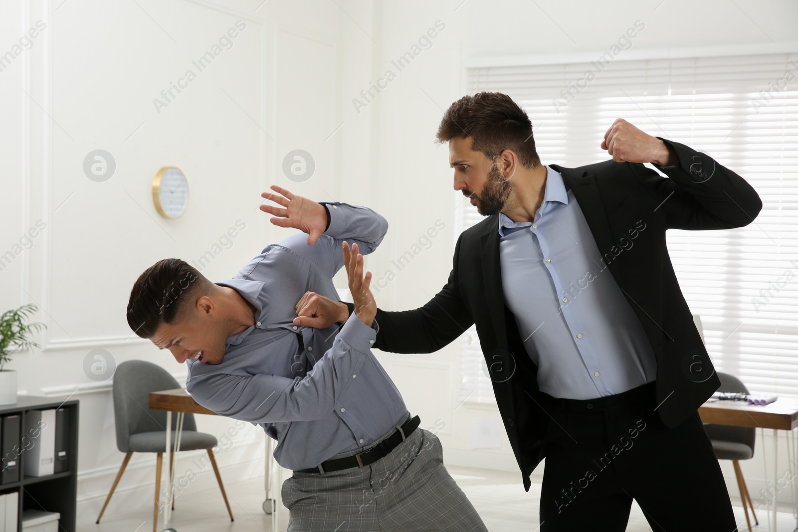 Photo of Emotional colleagues fighting in office. Workplace conflict