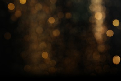 Photo of Blurred view of golden lights on black background. Bokeh effect