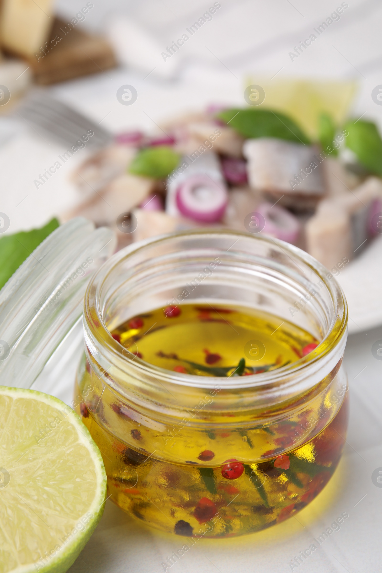 Photo of Tasty fish marinade in jar on light tiled table, closeup