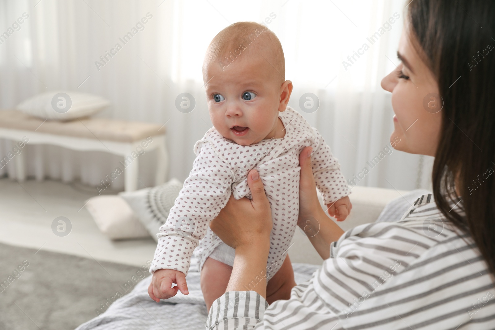 Photo of Young woman with her cute baby at home