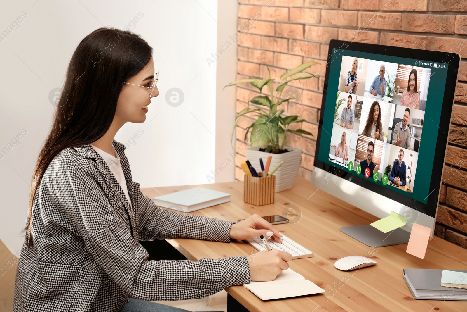 Image of Woman having video chat with colleagues at table in office. Team work 