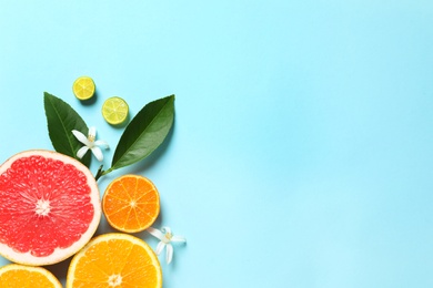 Photo of Flat lay composition with citrus fruits, leaves and flowers on color background. Space for text