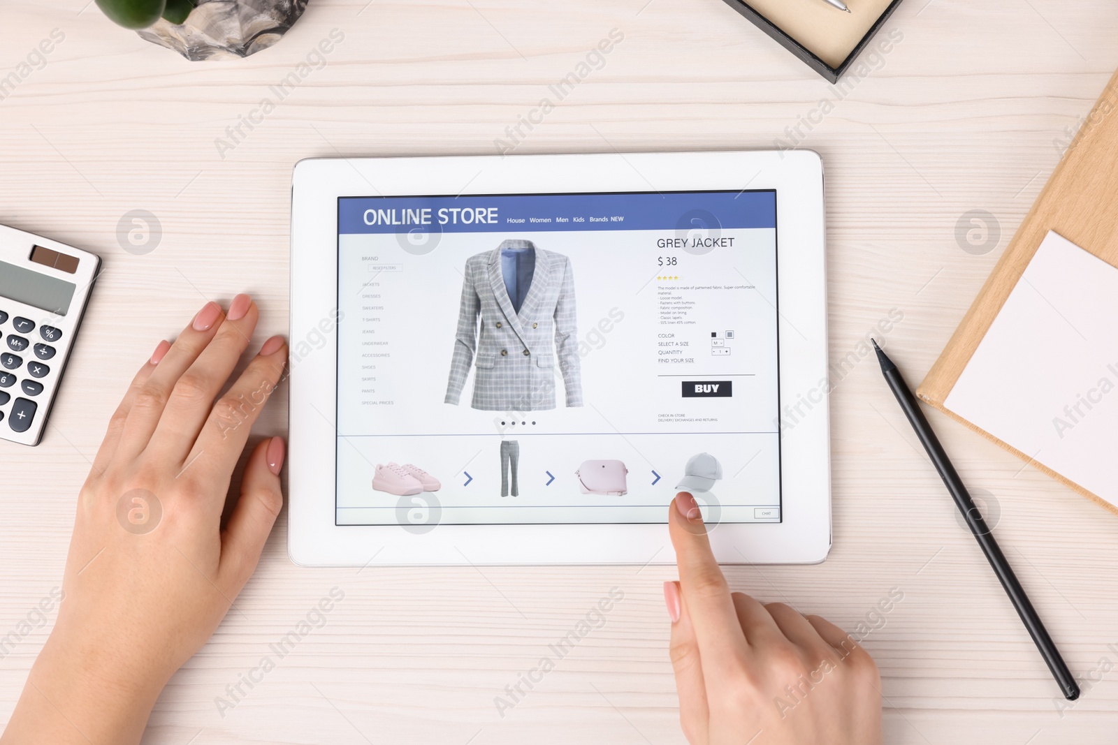 Photo of Woman with tablet shopping online at white wooden table, top view