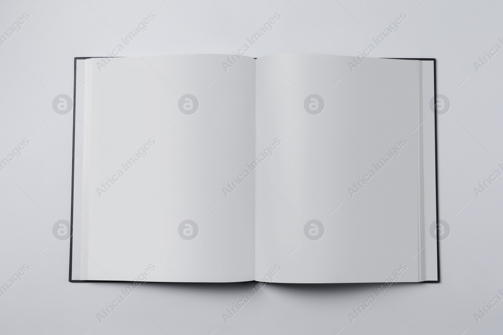 Photo of Open book on white background, top view