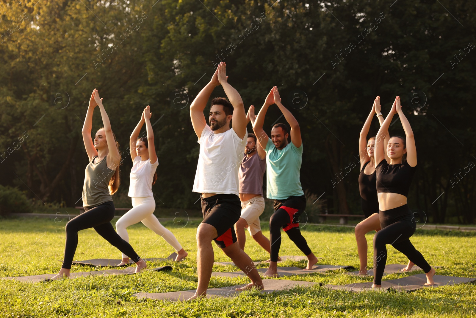 Photo of Group of people practicing yoga on mats outdoors