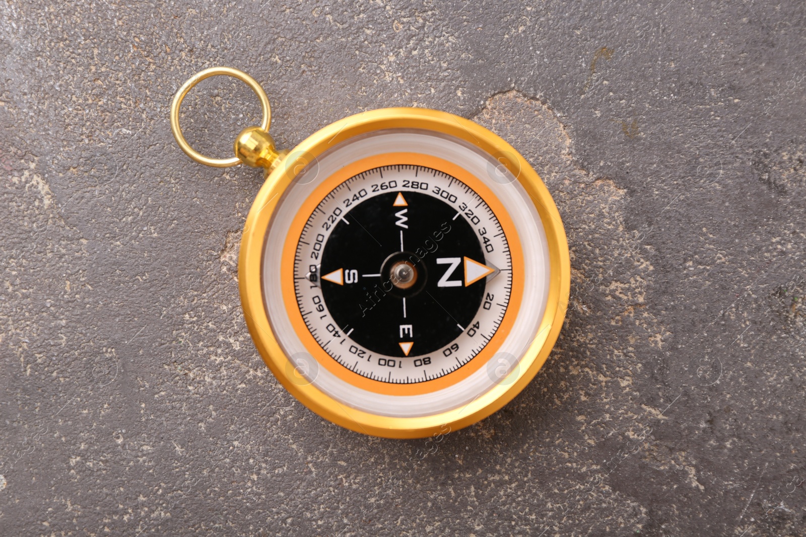 Photo of One compass on grey textured background, top view