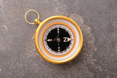 One compass on grey textured background, top view