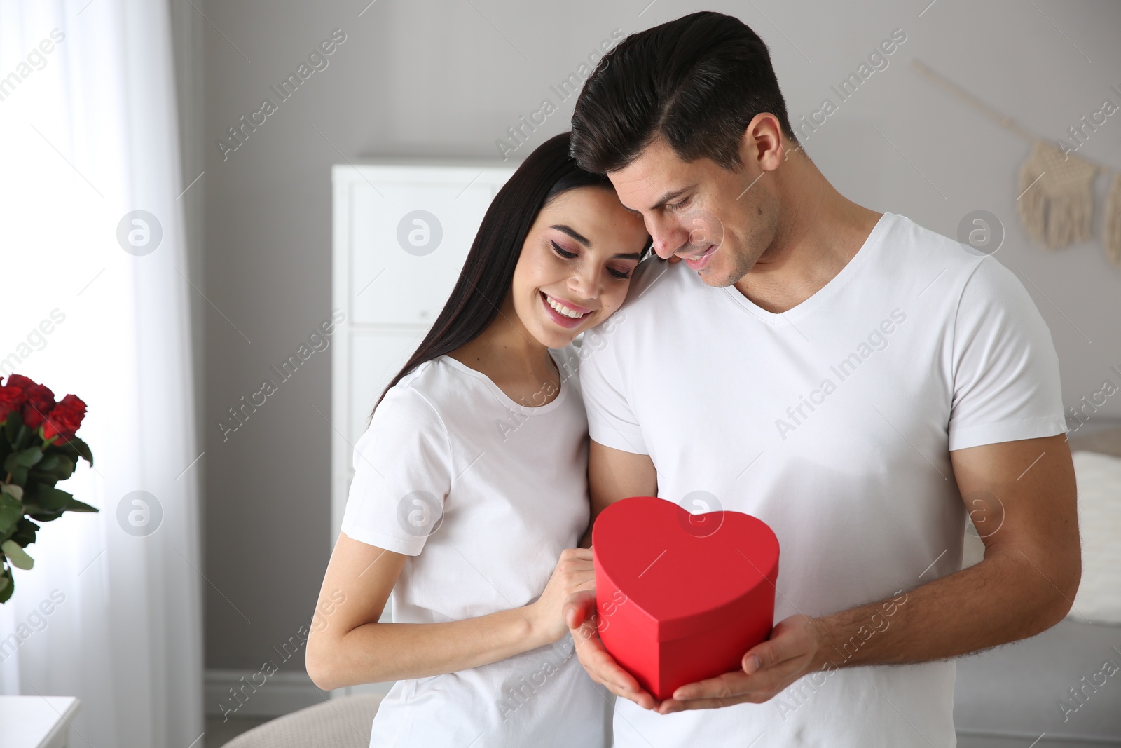 Photo of Lovely couple with gift box at home. Valentine's day celebration