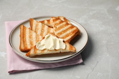 Photo of Tasty toasts with butter on light grey marble table