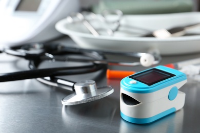 Stethoscope and blood pressure monitor on grey table. Medical objects