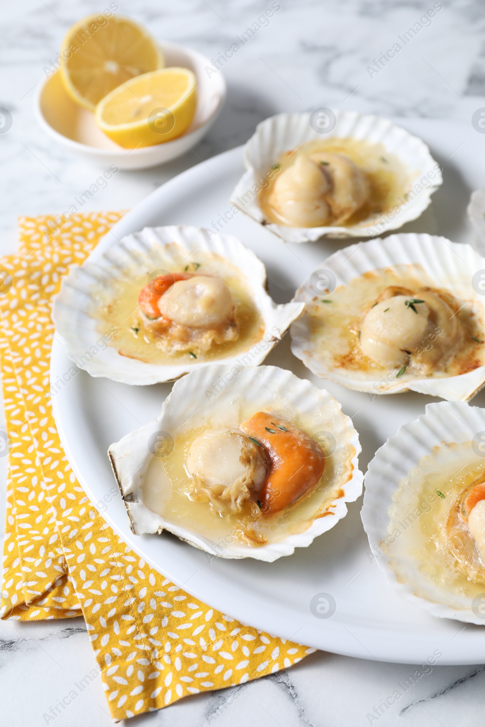 Photo of Fried scallops in shells on white marble table