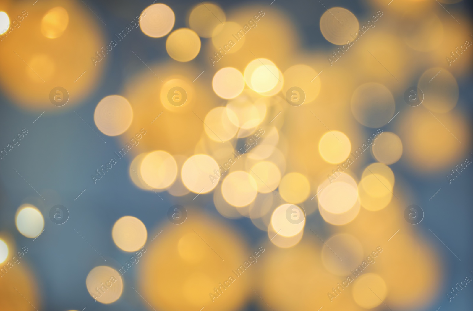 Photo of Blurred view of gold lights on dark background. Bokeh effect