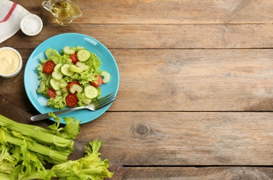 Delicious fresh celery salad served on wooden table, flat lay. Space for text