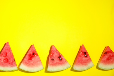 Photo of Watermelon slices on yellow background, flat lay. Space for text