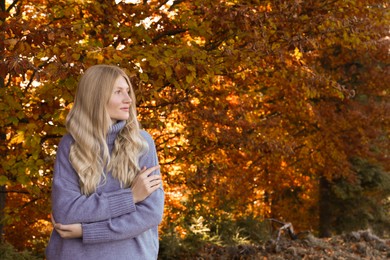 Photo of Portrait of beautiful young woman in autumn forest. Space for text