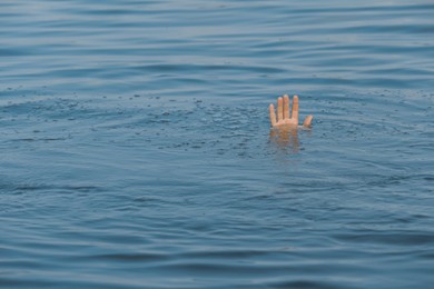 Photo of Drowning man reaching for help in sea, closeup