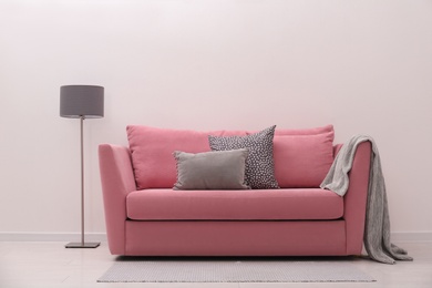 Photo of Simple room interior with comfortable pink sofa