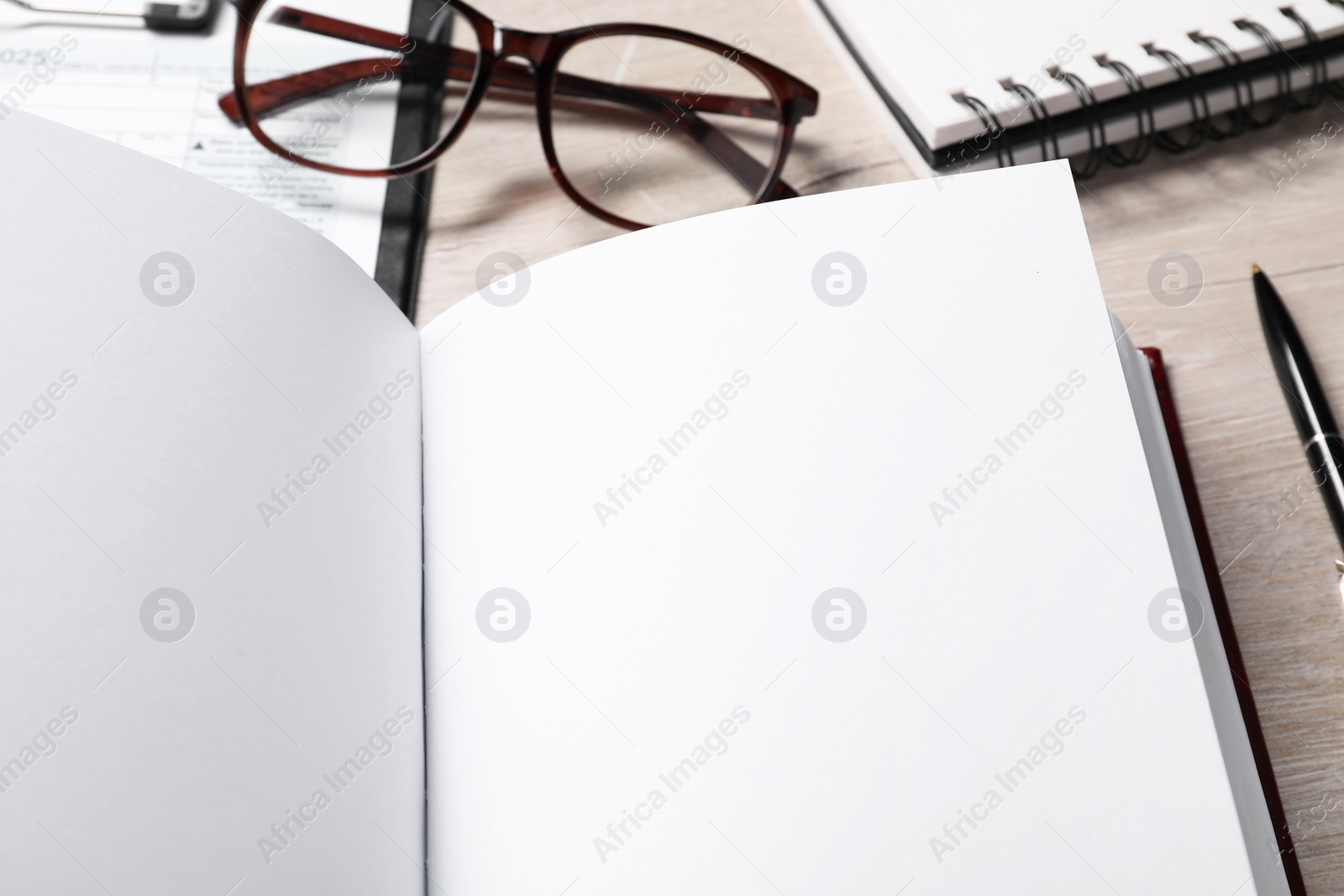 Photo of Law. Book, glasses, form and stationery on wooden table, closeup