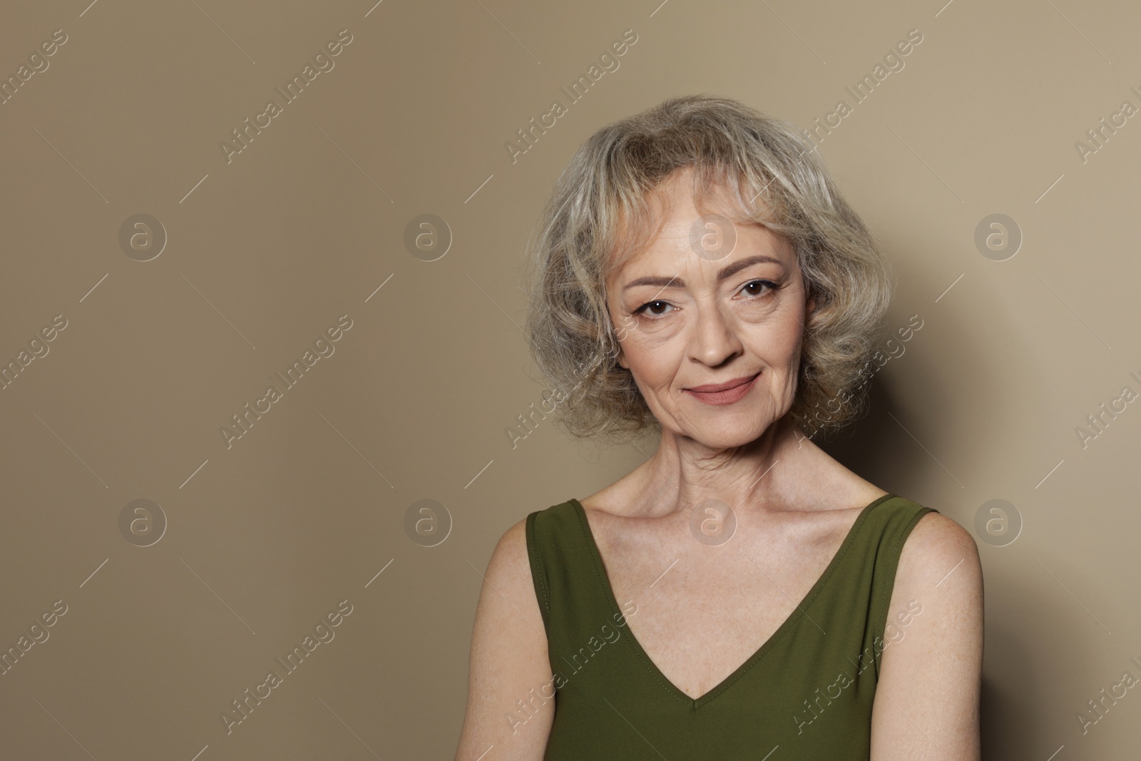 Photo of Portrait of mature woman on color background. Space for text