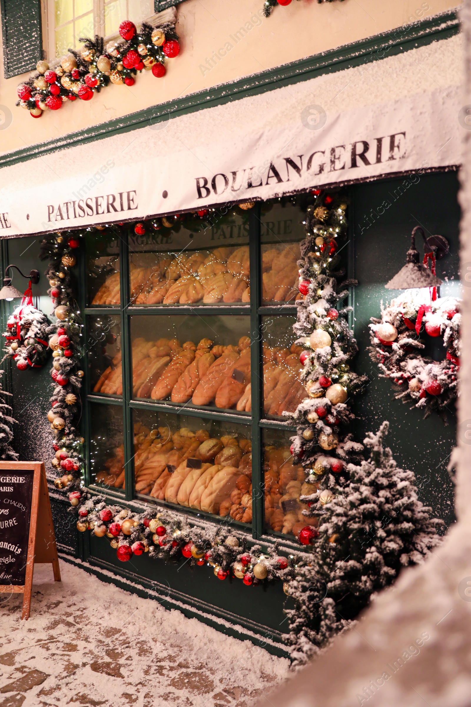 Photo of Bakery shop decorated with Christmas garland outdoors