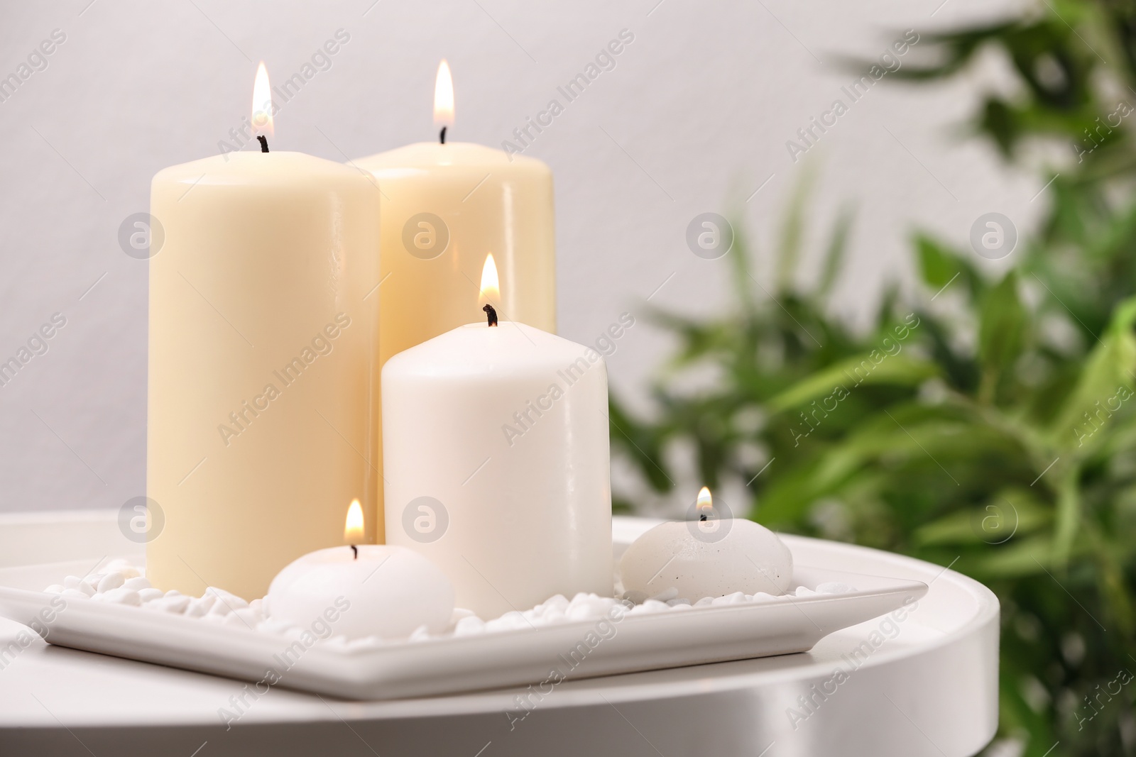 Photo of White plate with different candles on table. Space for text