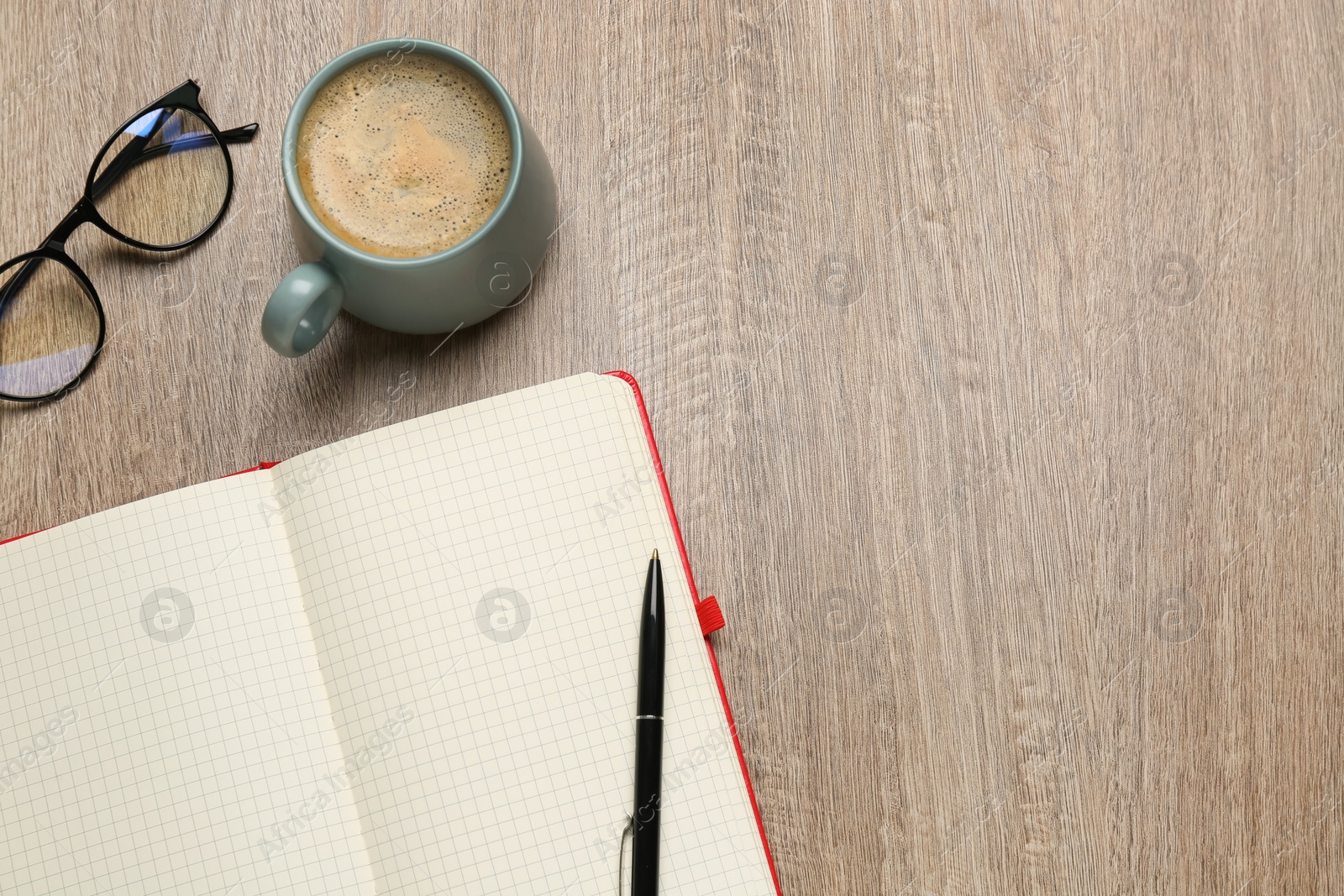 Photo of Blank notebook, cup of coffee and glasses on wooden table, flat lay. Space for text