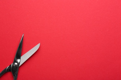 Photo of Pair of sharp scissors on color background, top view. Space for text