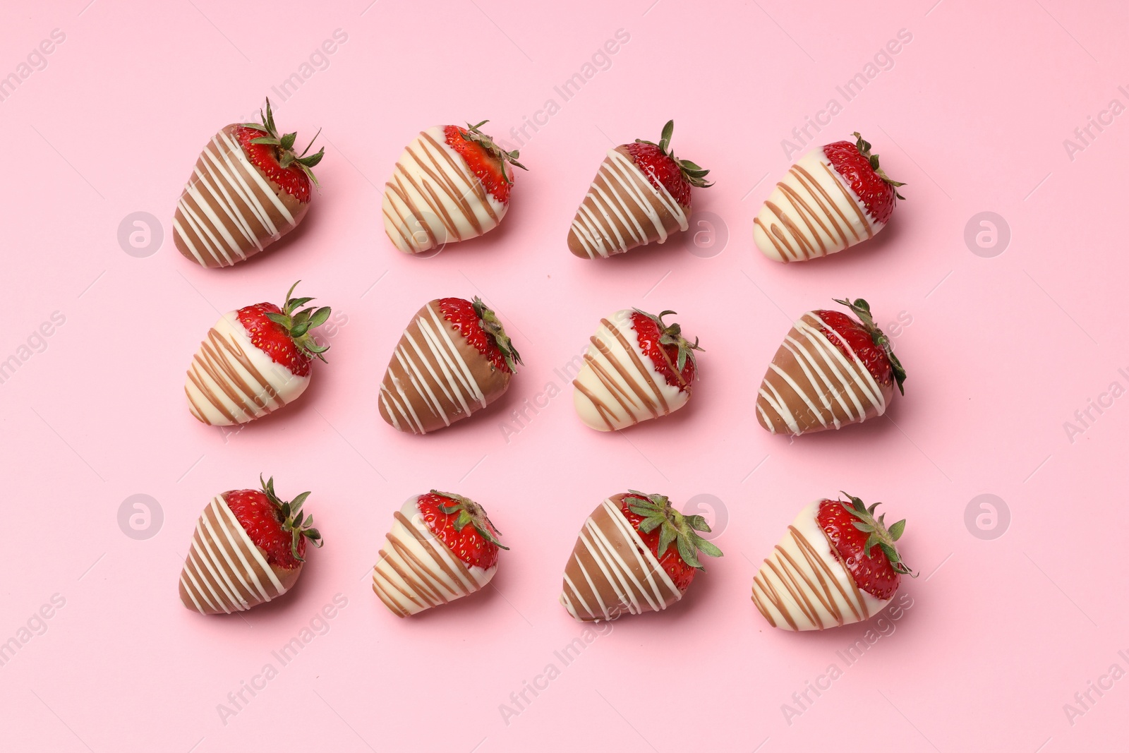 Photo of Delicious chocolate covered strawberries on pink background, flat lay